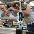 At the Skoltech composite lab, senior research scientist Fedor Antonov (right) and Mikhail Golubev, a design engineer, operate a 3D printer which produces a stiff and resilient composite material. The Moscow based team of researchers now aims to register 